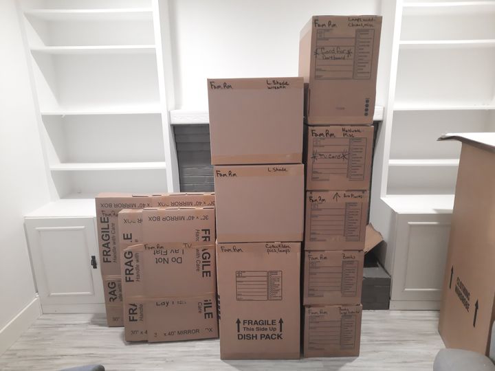 Packed moving boxes stacked in a room (Packing services) by Moving Pros CLE