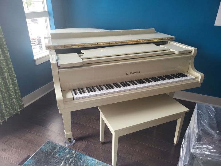 White baby grand piano in a home (Piano Moving) by Moving Pros CLE